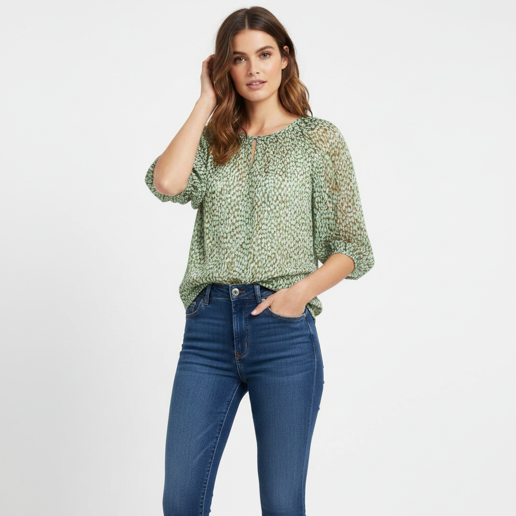 Model wearing CAbi pebble blue-green print blouse on white studio background